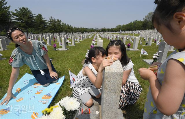 6.25 68주년을 하루 앞둔 24일 동작구 국립서울현충원 묘역을 찾은 채현주씨가 가족들과 함께 지난 1952년 8월 2일 경기도 가평에서 전사한 할아버지 고(故) 채홍수 씨의 묘비에서 참배하고 있다. 서재훈 기자