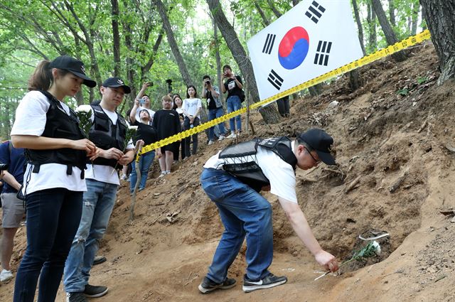 25일 강원 홍천군 화촌면 풍천리 일대에서 발굴된 6·25 전사자 유해 앞으로 서경덕 성신여대 교수가 헌화하고 있다. 홍천=연합뉴스