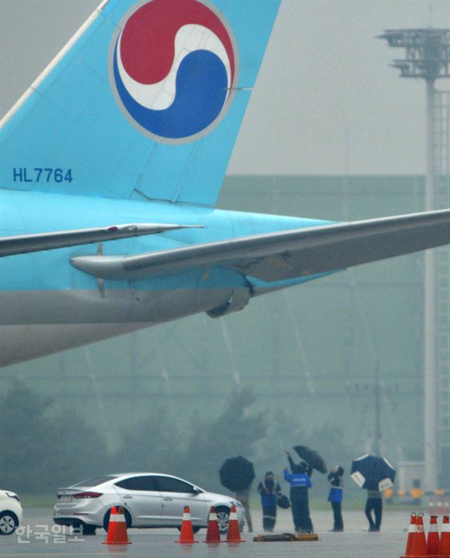 26일 오전 김포공항 활주로에서 사고 조사관들이 대한항공과 아시아나항공의 비행기 접촉 사고를 조사하며 대한항공 비행기의 파손된 부분을 확인하고 있다. 이날 오전 8시께 김포공항 주기장에서 이륙 전 탑승 게이트로 이동하던 아시아나항공 OZ3355편의 날개와 대한항공 KE2725편의 후미 꼬리 부분이 부딪히는 접촉사고가 발생 항공기가 손상됐다. 신상순 선임기자 ssshin@hankookilbo.com