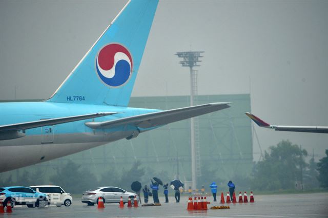 26일 오전 김포공항 활주로에서 사고 조사관들이 대한항공과 아시아나항공의 비행기 접촉 사고를 조사하며 대한항공 비행기의 파손된 부분을 확인하고 있다. 신상순 선임기자