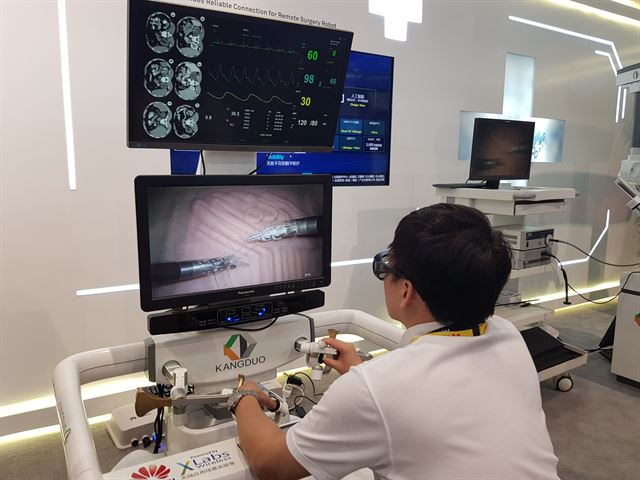 27일 중국 상하이에서 개막한 '모바일월드콩그레스(MWC) 상하이 2018'에서 화웨이 관계자가 3차원(3D) 안경을 쓰고 화면을 보면서 원격 봉합 수술을 시연하고 있다.