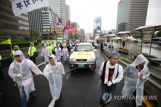 금속노조 쌍용차지부 관계자들이 지난 4월 22일 쌍용차 해직자 전원복직과 손해배상·가압류 철회를 요구하며 자동차를 끌고 행진하고 있다. 연합뉴스