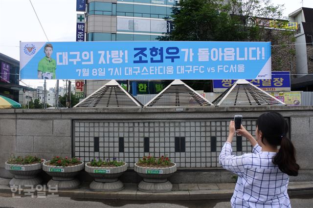 [저작권 한국일보]대구시민이 28일 대구 도심에서 월드컵 한국대표팀 조현우 골키퍼의 귀국 홈경기를 홍보하는 플래카드를 기념촬영하고 있다. 윤희정기자