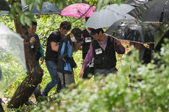 지인을 살해하고 시신을 인근 야산에 암매장한 뒤 여장을 한 채로 은행에서 돈을 찾은 피의자 박모씨(48)가 26일 오전 서울 노원구 수락산 능선에서 현장검증을 마친 후 내려오고 있다.박씨는 지난 8일 평소 알고 지내던 50대 남성 A씨를 흉기로 살해하고 시신을 서울 노원구 소재 야산에 유기한 혐의를 받는다.뉴스1