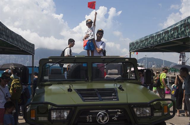 한 어린이가 1일 홍콩 인민해방군 해군 기지에서 열린 부대 공개행사에서 군용차에 올라 중국 오성홍기를 흔들고 있다. 홍콩=EPA 연합뉴스