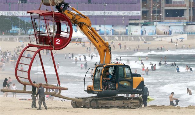 제7호 태풍 '쁘라삐룬'이 북상 중인 2일 부산 해운대해수욕장에서 119수상구조대원들이 근무하는 망루가 철거되고 있다. 해운대구는 태풍에 대비해 백사장에 있는 해변라디오 북카페, 장애인 통행로 등을 이동시키고 피서용품도 안전한 곳으로 옮겼다. 부산=연합뉴스