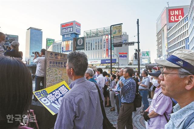 지난달 5일 저녁 일본 도쿄 신주쿠역 서쪽 출구에서 열린 아베 정권 반대 집회에서 참여자들이 구호를 외치며 전단을 나눠주고 있다.상당수가 50~70대인 이들은 조용하지만 확실하게 메시지를 전달할 뿐 어떤 종류의 폭력도 내비치지 않았다. [저작권 한국일보] 박소영기자