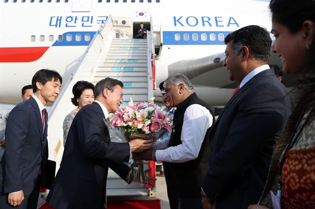 인도를 국빈 방문중인 문재인 대통령 내외가 8일 인도 뉴델리 팔람 공군공항에 도착해 싱 인도 영예 수행장관으로부터 꽃다발을 받고 있다. 뉴델리=고영권 기자