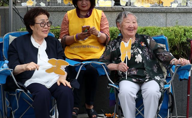 11일 오후 서울 종로구 일본대사관 앞 평화로에서 열린 '1343차 일본군성노예제 문제해결을 위한 정기 수요시위'에 참석한 이용수(왼쪽) 할머니와 길원옥 할머니가 미소를 짓고 있다.