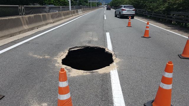 11일 낮 12시 30분께 부산 도시고속도로 번영로 원동에서 서울 방향 200ｍ 지점에 가로 2ｍ, 세로 1ｍ, 깊이 5ｍ가량의 싱크홀이 발생해 교통이 통제 중이다. 부산경찰청 제공=연합뉴스