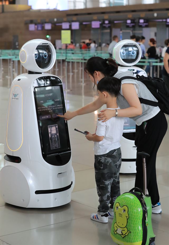 인천국제공항 1터미널 출국장에서 한 가족이 안내로봇 '에어스타'를 조작해보고 있다. 연합뉴스