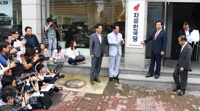 자유한국당 여의도 당사를 비우고 영등포동의 한 빌딩으로 입주한 11일 김성태 당대표 권한대행과 안상수 비대위 준비위원장이 입주에 앞서 현판을 걸고 있다.오대근기자 inliner@hankookilbo.com