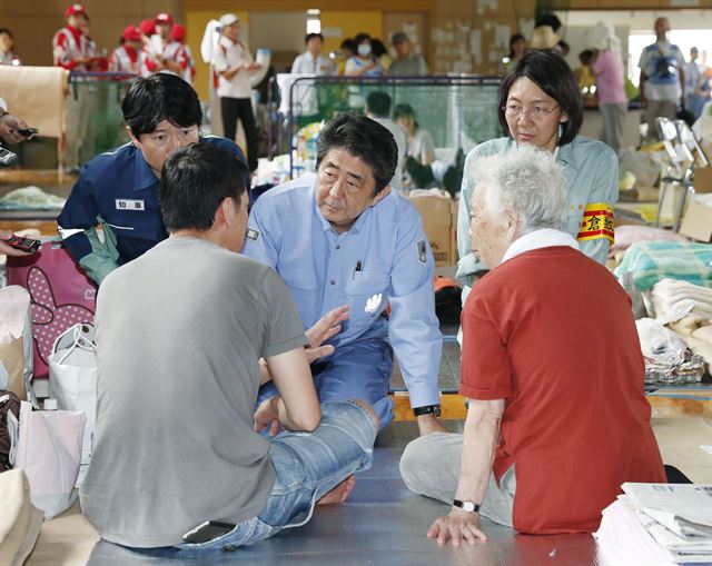 최근 내린 폭우로 일본 정부와 지방자치단체의 부실 대응에 대한 논란과 술자리와 회식에 참석한 사실이 잇따라 드러나 비난을 받고 있는 아베 신조 일본 총리가 11일(현지시간) 뒤늦게 수해지역인 오카야마현 구라시키의 대피소를 방문해 무릎을 끓은 채 수재민들과 대화를 하고 있다. 교도뉴스,AP 연합뉴스