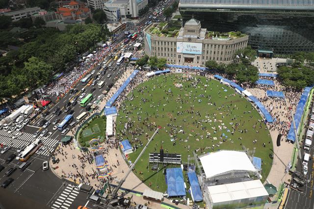 14일 오후 서울광장에서 성(性)소수자 축제인 제19회 서울퀴어문화축제의 대표 행사 '서울퀴어퍼레이드'를 하고 있다. 그 옆 대한문 앞에서는 ‘서울퀴어문화축제 반대집회’를 하고 있다. 연합뉴스