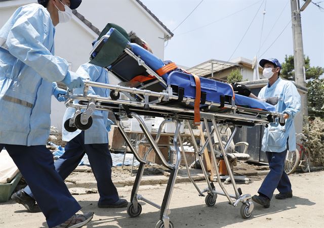 일본 서부지역이 최근 폭우로 큰 피해를 본 가운데 15일 오카야마(岡山)현 구라시키(倉敷)시 마비초(眞備町)에서 온열질환 증세를 보인 사람이 응급 이송되고 있다. 연합뉴스