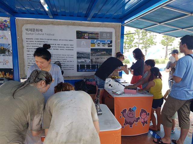 보령머드축제장을 찾은 관광객에게 백제문화제추진위원회 직원들이 백제문화제를 홍보하고 있다. 백제문화제추진위 제공