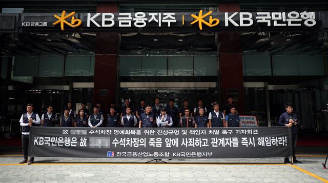 18일 오전 서울 영등포구 KB국민은행 여의도본점 앞에서 전국금융산업노동조합 국민은행지부 노조원들이 실적압박 및 업무부담으로 직원 A씨가 스스로 목숨을 끊은 사건에 대한 책임자 처벌 촉구 기자회견을 하고 있다. 연합뉴스