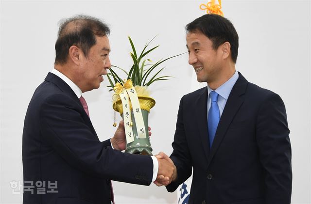 김병준(왼쪽) 자유한국당 혁신비대위원장이 19일 국회에서 인사차 방문한 한병도 청와대 정무수석으로부터 대통령 문재인 이라고 적힌 취임 축하난을 전달받고 있다. 오대근 기자 inliner@hankookilbo.com