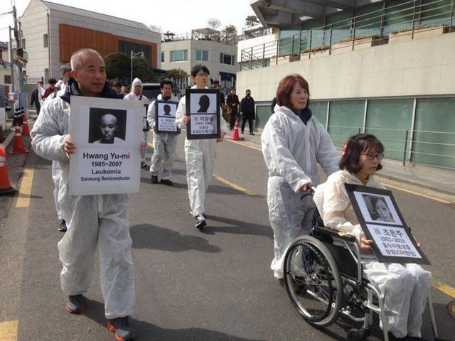 지난 3월 6일 서울 용산구 삼성미술관 리움 앞에서 열린 고(故) 황유미씨 11주기 기자회견 참가자들이 백혈병 사망자들의 영정을 든 채 행진하고 있다. 반올림 제공