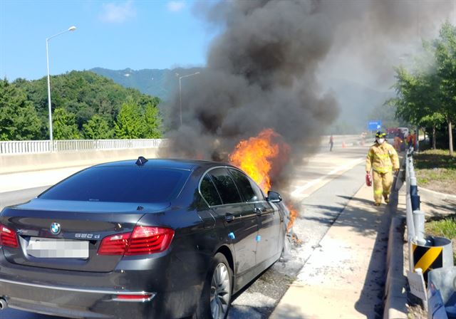 지난 15일 경북 영주시 장수면 중앙고속도로 춘천 방향 영주휴게소 입구에서 BMW 520d 승용차 엔진 룸에서 불이 나 소방대원들이 진화에 나서고 있다. 영주소방서 제공