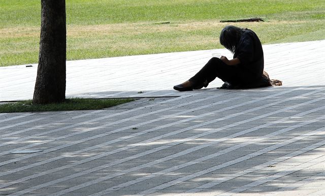 연일 이어지는 폭염으로 사람이나 가축이나 힘겹다. 22일 서울광장에서 나무 그늘 끝에 앉아 더위를 피하는 노숙자의 모습. 연합뉴스