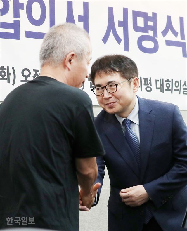 황상기(왼쪽) 반올림 대표와 김선식 삼성전자 전무가 24일 오전 서울 서대문구 법무법인 지평에서 '삼성전자-반올림-조정위원회 제2차 조정재개 및 중재합의서 서명식'을 마친 후 악수하고 있다. 홍인기 기자