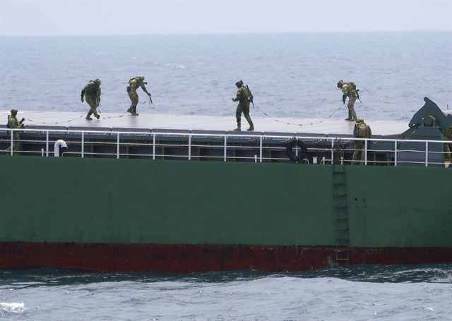 일본 도쿄 남동부 보소반도 해안에서 25일(현지시간) 일본, 미,호주,한국 등이 '대량살상무기 확산방지구상(PSI)'의 해상저지 훈련인 '퍼시픽 쉴드 18'이 실시되고 있는 가운데 미 해안경비대 소속 대원들이 모의 선박을 살펴보고 있다. AP 연합뉴스