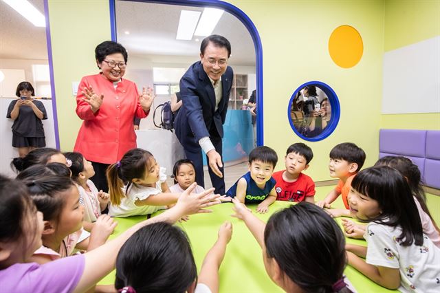 조용병 신한금융그룹 회장이 24일 정현백 여성가족부 장관과 함께 서울 서대문구 연희동에 문을 연 ‘신한 꿈도담터 1호점’을 찾아 아이들과 인사를 하고 있다. 신한금융그룹 제공