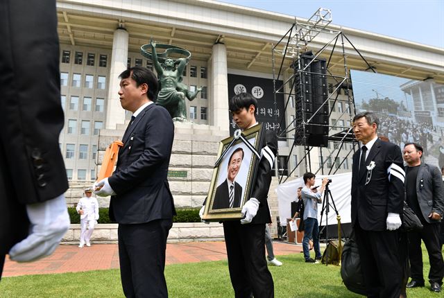 27일 오전 서울 여의도 국회에서 열린 故 노회찬 정의당 원내대표 영결식 후 유족들이 고인의 영정을 들고 의원회관으로 향하고 있다. 오대근 기자