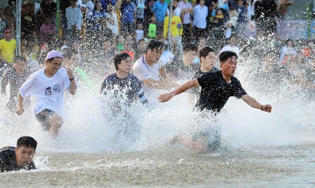 29일 경북 봉화군 봉화읍 체육공원과 내성천 일원에서 열리고 있는 제20회 봉화은어축제를 찾은 관광객들이 내성천에서 시원한 물속 달리기를 하며 더위를 식히고 있다. 연합뉴스