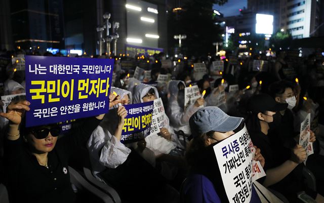 6월 서울 종로구 동화면세점 앞에서 열린 난민법과 무사증(무비자) 제도 폐지 집회에서 참가자들이 손팻말을 들고 있다. 연합뉴스