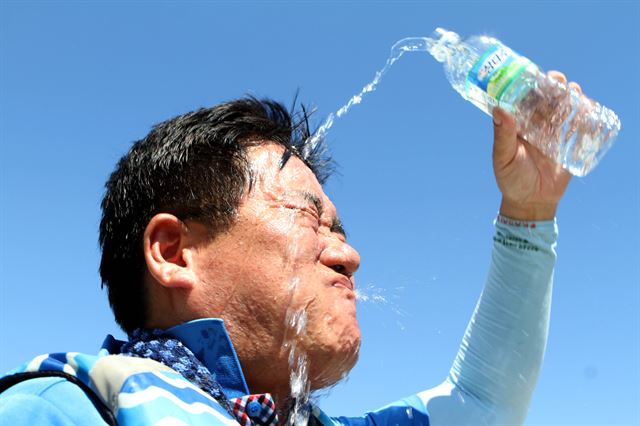 1일 오후 강원 화천군 쪽배축제장에서 열린 화천군청 공무원 용선경주대회를 마친 참가자가 얼굴에 물을 뿌리며 더위를 식히고 있다. 뉴시스