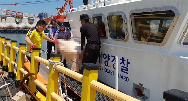 지난달 25일 제주시 구좌읍 세화포구에서 실종된 최모씨가 1일 섬 반대편인 서귀포시 가파도 서쪽 해상에서 숨진 채 발견됐다. 신고를 받고 출동한 해양경찰 관계자가 최씨 시신을 옮기고 있다. 서귀포해양경찰서 제공