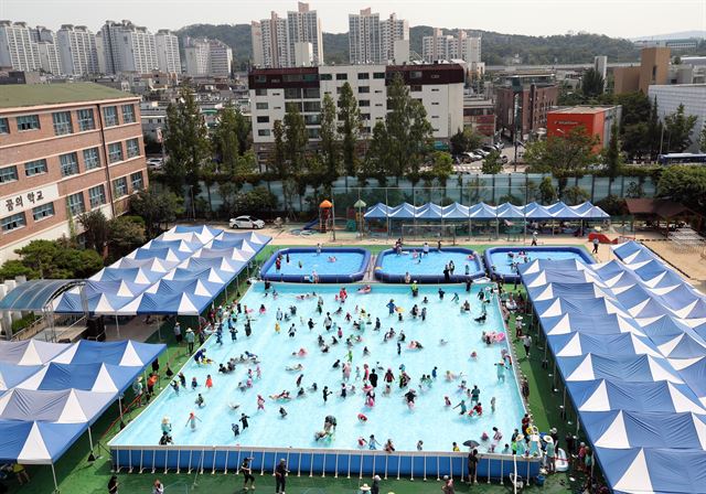 3일 성북구 서울 숭례초등학교 운동장에 설치된 물놀이장에서 어린이 등이 더위를 식히고 있다. 연합뉴스