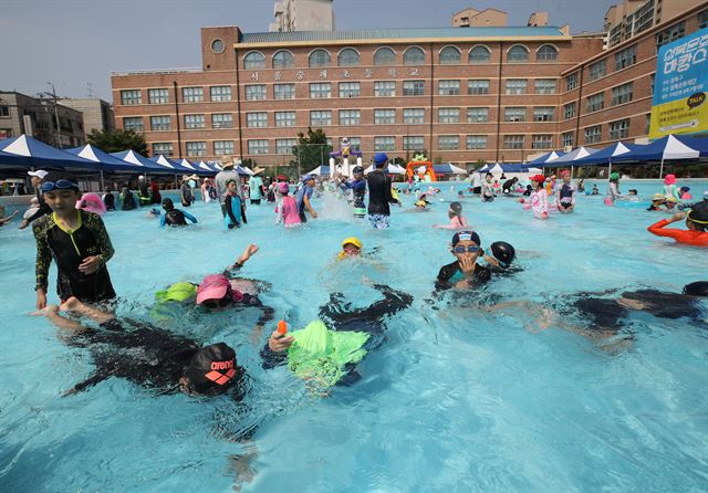 3일 성북구 서울 숭례초등학교 운동장에 설치된 물놀이장에서 어린이 등이 더위를 식히고 있다. 연합뉴스