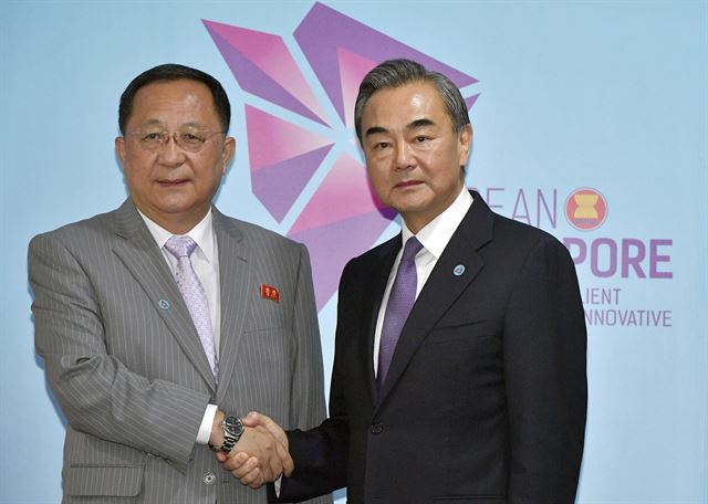 아세안(ASEAN·동남아국가연합) 관련 외교장관회의 참석차 싱가포르를 방문한 리용호 북한 외무상(왼쪽)과 왕이 중국 외교부장이 3일(현지시간) 엑스코 컨벤션센터에서 양자회담에 앞서 악수하고 있다. 리 외무상과 왕 부장은 이날 회담에서 종전선언, 유엔 안전보장이사회의 대북제재 완화, 경제협력 등에 관해 의견교환을 한 것으로 관측된다. 연합뉴스