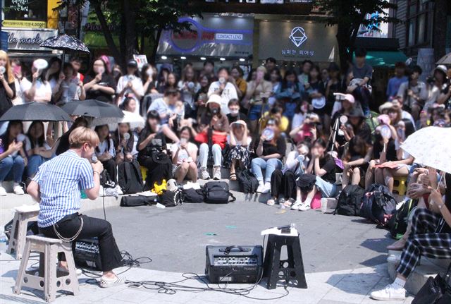 보컬그룹 동급생 멤버인 허성정이 지난달 24일 홍익대 인근 길거리 공연을 하고 있다. 그늘 한 점 없는 뙤약볕에 휴대폰을 놔뒀더니 갑자기 기기가 꺼져 공연이 중단됐다. 과열로 꺼진 휴대폰에는 MR(반주만 녹음된 음원)이 들어 있었다. HF뮤직컴퍼니 제공