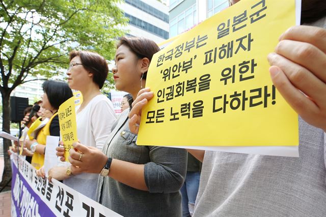 6일 오전 서울 중구 화해치유재단 앞에서 열린 재단 해산 촉구 기자회견에서 참석자들이 위안부 피해자 인권회복을 촉구하는 손팻말을 들고 있다. 이날 폭염 때문에 고령의 피해자 할머니들은 참석하지 못했다. 연합뉴스