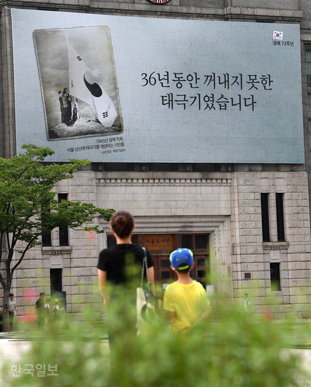 13일 서울광장 꿈새김판에 광복절 기념 현수막이 걸려 있다. '36년 동안 꺼내지 못한 태극기였습니다'라는 문구와 함께 광복 직후 남산에서 대형 태극기를 게양하는 시민들의 모습을 찍은 사진과 설명문이다. 서재훈 기자 spring@hankookilbo.com