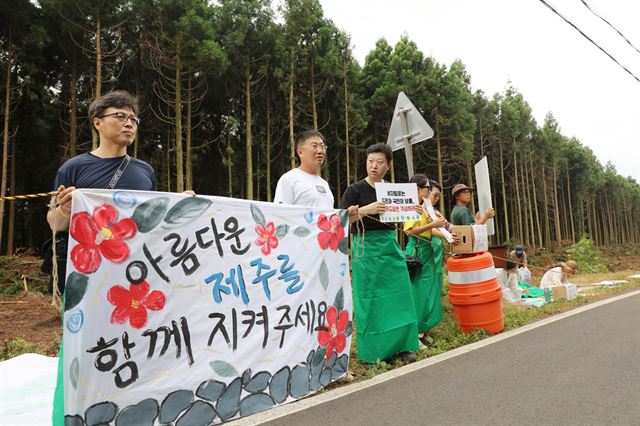 제주 '비자림로를 지키려는 시민 모임' 참가자들이 12일 오전 비자림로 확장 공사 현장에서 공사 중단을 촉구하는 시위를 벌이고 있다. 연합뉴스