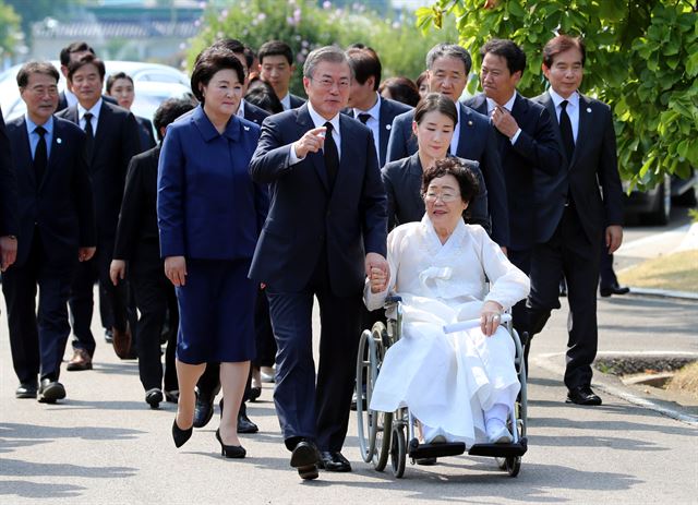 일본군 ‘위안부' 피해자 기림의 날 첫 정부 기념식이 열린 14일 오후 문재인 대통령이 이용수 할머니의 손을 잡고 기념식이 열리는 충남 천안 국립 망향의 동산 안 모란묘역으로 이동하고 있다. 고영권기자