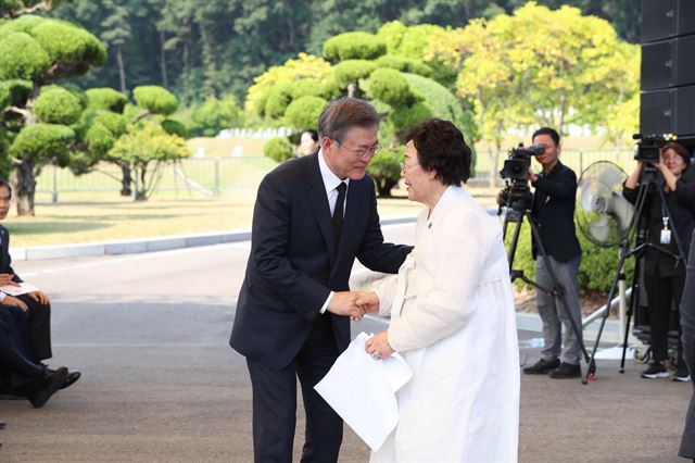 문재인 대통령이14일 충남 천안 국립 망향의 동산 모란묘역에서 열린 ‘일본군 위안부 피해자 기림의 날’ 행사에서 이용수 함머니의 손을 잡고 있다. 국민들의 올바른 역사 정립과 여성인권 증진을 위해 국가기념일로 지정됐고 이번이 지정 이후 첫 번째 기념식이다. 천안=고영권 기자