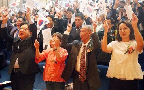 15일 중국 베이징 주중 한국대사관에서 열린 광복절 경축식에서 애국지사 김산의 아들 고영광(오른쪽 두번째) 선생과 재중 작곡가 정율성 선생의 딸 정소제(오른쪽 세번째) 여사가 만세를 부르고 있다. 연합뉴스