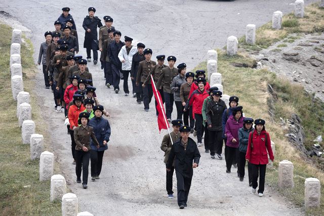 북한 노동자들이 18일 백두산 정상에 올라 천지를 구경한 후 줄을 지어 하산하고 있다. AP 연합뉴스