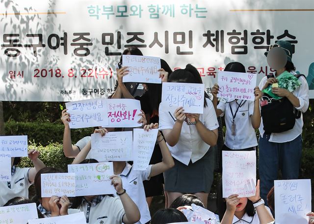 서울 동구여중 학생들이 22일 종로구 서울시교육청 인근 경희궁 앞마당에서 학교 정상화를 촉구하는 글귀를 담은 손팻말을 들고 시위하고 있다. 연합뉴스