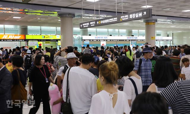 [저작권 한국일보]22일 오후 제19호 태풍 ‘솔릭’의 영향으로 제주지역 기상이 악화되면서 항공사들이 제주기점 항공기를 무더기 결항 조치한 가운데 항공권을 구하려는 관광객들로 제주공항이 북새통을 이루고 있다. 김영헌 기자.