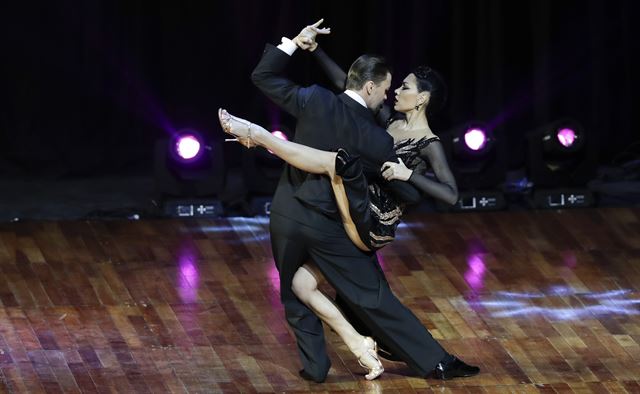 아르헨티나 부에노스아이레스에서 22일(현지시간) '탱고 세계 선수권대회(Tango World Championships)' 이 열리고 있는 가운데 스테이지 부문 최종전에서 우승한 러시아의 드미트리 바신과 사그디아나 캄지나 커플이 화려한 안무를 선보이고 있다. AP 연합뉴스