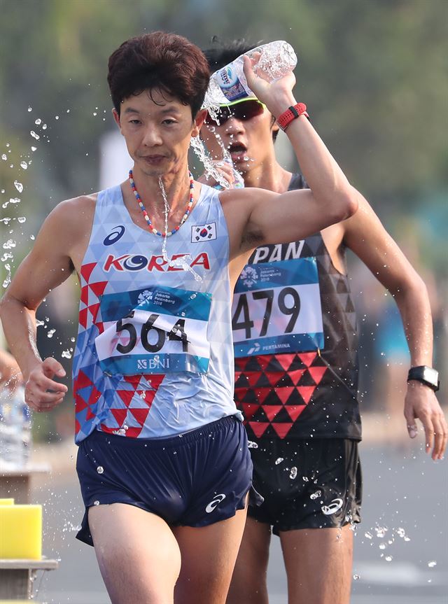 김현섭이 29일 자카르타-팔렘방 아시안게임 남자 경보 20km에 출전해 생수로 무더위를 식혀가며 달리고 있다. 자카르타=연합뉴스