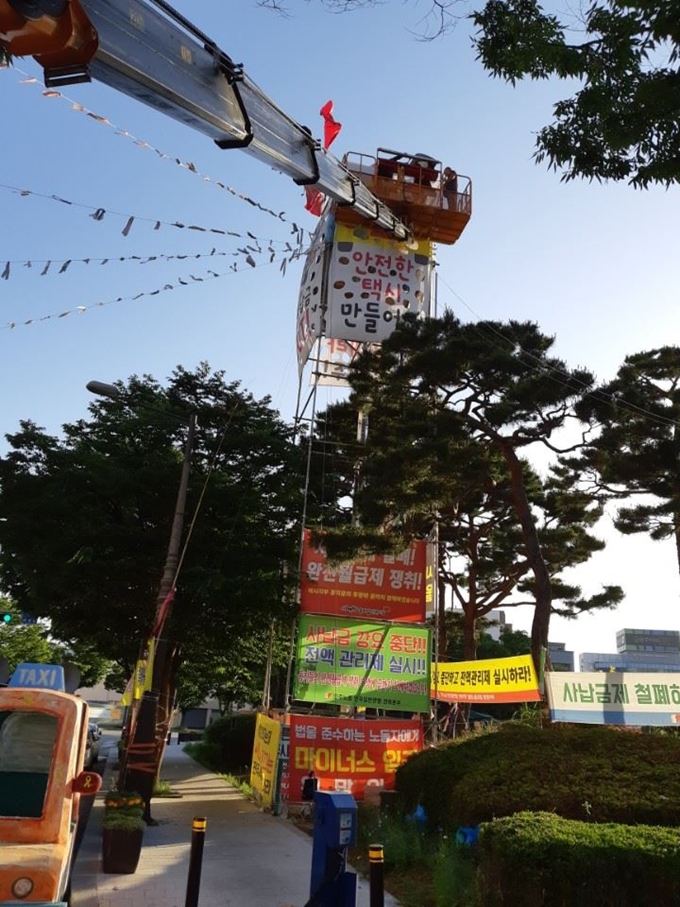 김씨가 1년 째 농성 중인 고공농성장 아래 쪽에 “사납금 강요를 중단하고 전액관리제를 실시하라”는 요구사항이 붙어 있다. 공공운수노조 택시지부 제공