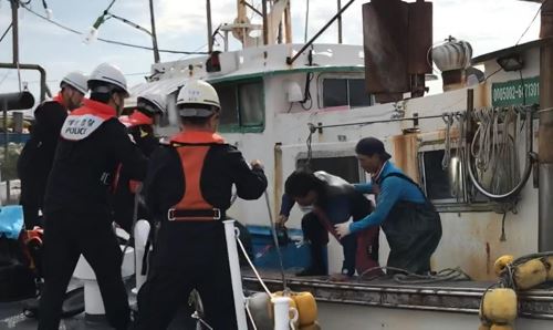 31일 오전 부산 기장군 학리항 앞바다에서 구조된 다이버(맨 오른쪽에서 두 번째)가 해양경찰 경비함정으로 옮겨타고 있다. 이 다이버는 실종 지점에서 66km 가량 떠내려가 인근을 지나던 어선에 구조됐다. 부산해경 제공